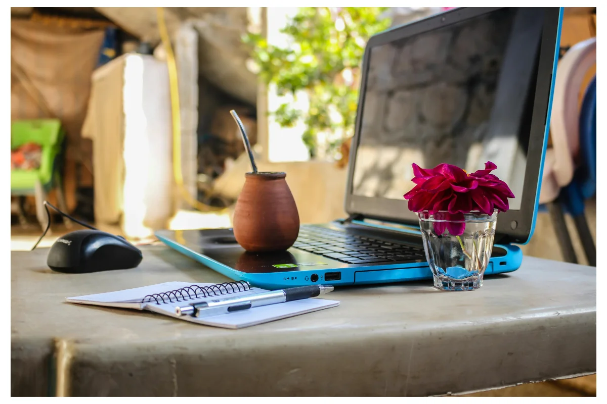 A Laptop Placed On a Table Alongside a Notebook And a Pen. Side Hustle