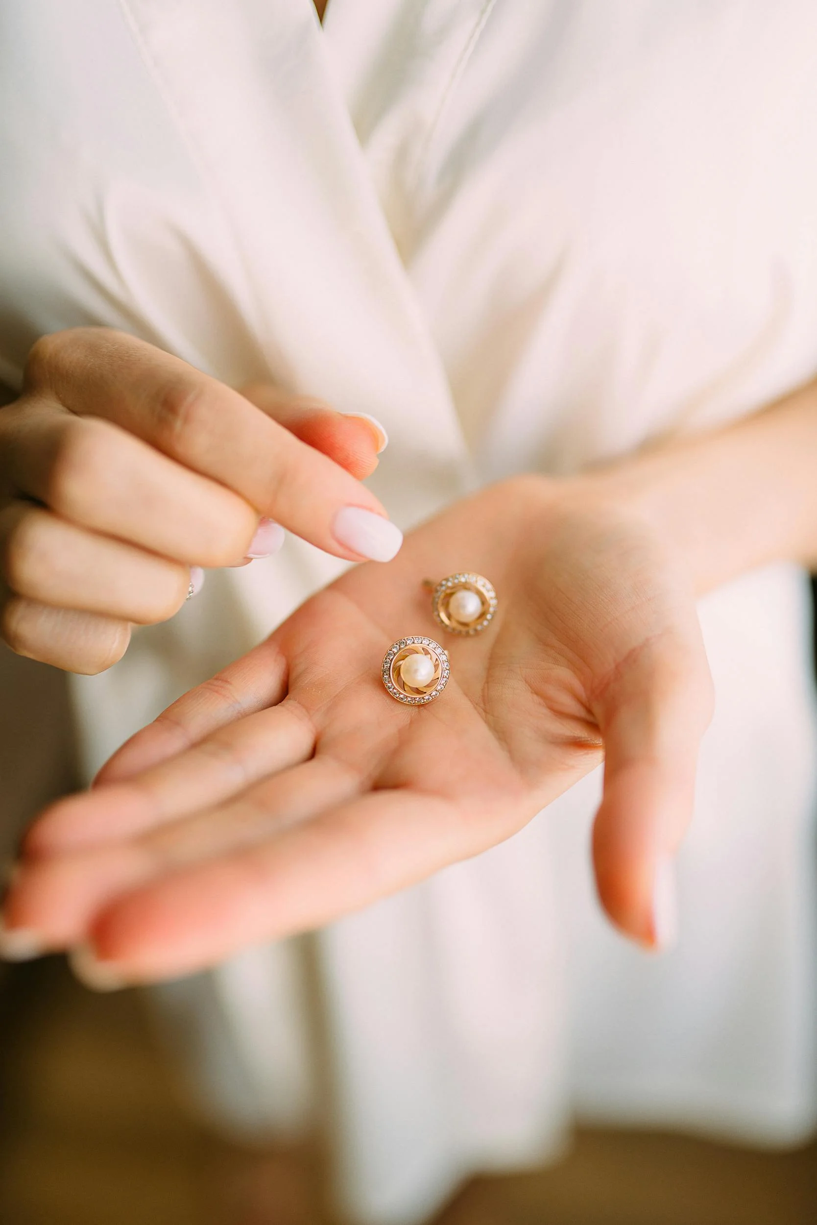 A Hand of a Woman Holding Ear Studs. Best Items to Resell For Profit.