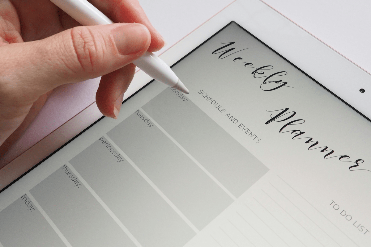 Weekly planner open on a tablet screen, showcasing how to make money with ChatGPT by creating and selling digital products