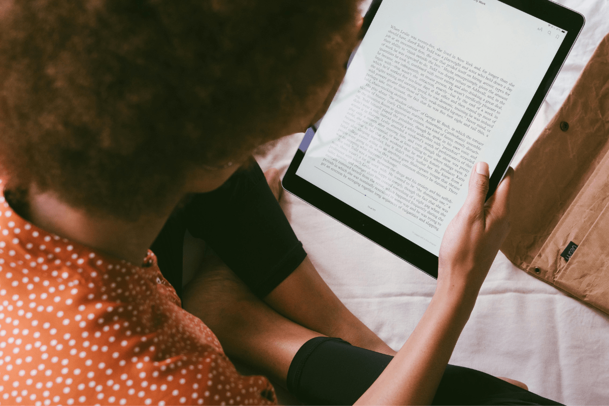 A Girl Reading an eBook on Her Tablet illustrating How to Create Digital Products and Make Money.