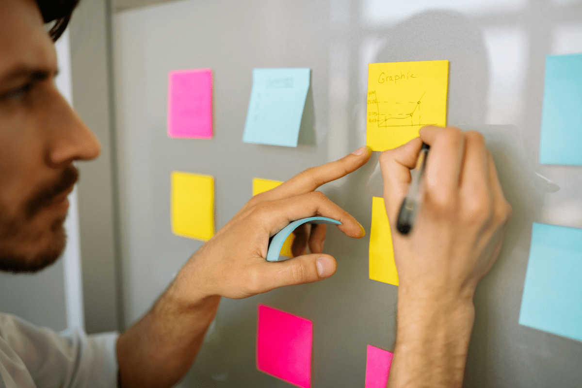Business Expansion Tips - How to Start a Real Estate Business A Person Writing Down Marketing Strategies and Tips Illustrating How to Start a Real Estate Business and Grow It.