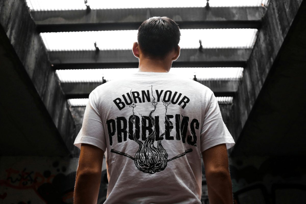 Person's back wearing a t-shirt with a motivational slogan, highlighting the potential to make money with AI using the print-on-demand business.