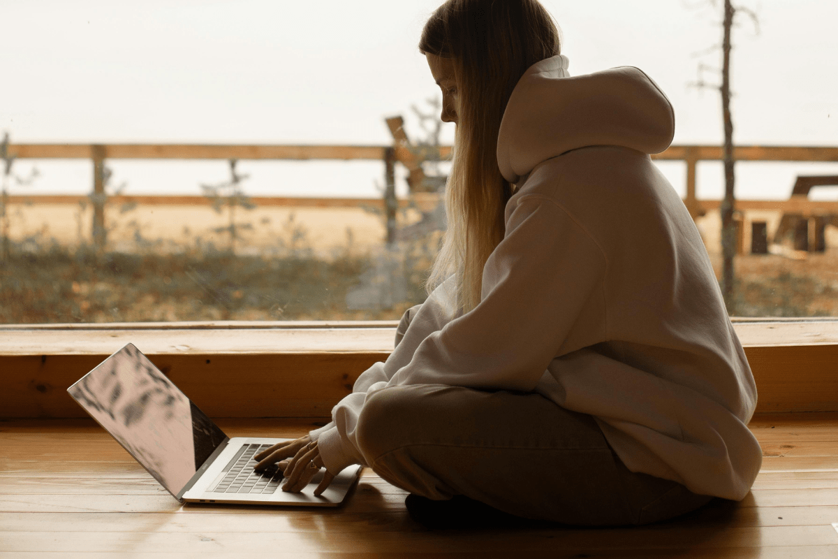 A Teenage Girl Sitting on Floor While Working on Her Laptop Illustrating Side Hustles for Teens