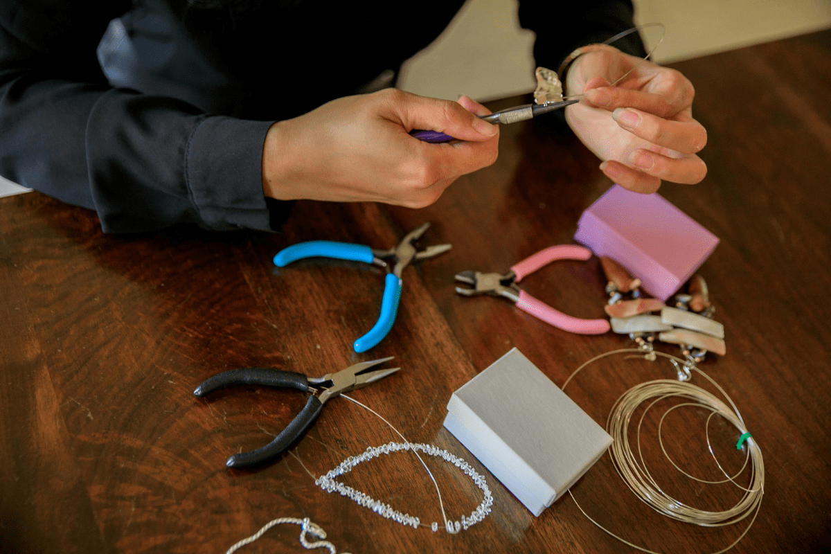 A Person's Hands are visible Making Jewelry by Hand Illustrating How to Start a Jewelry Business on Instagram 