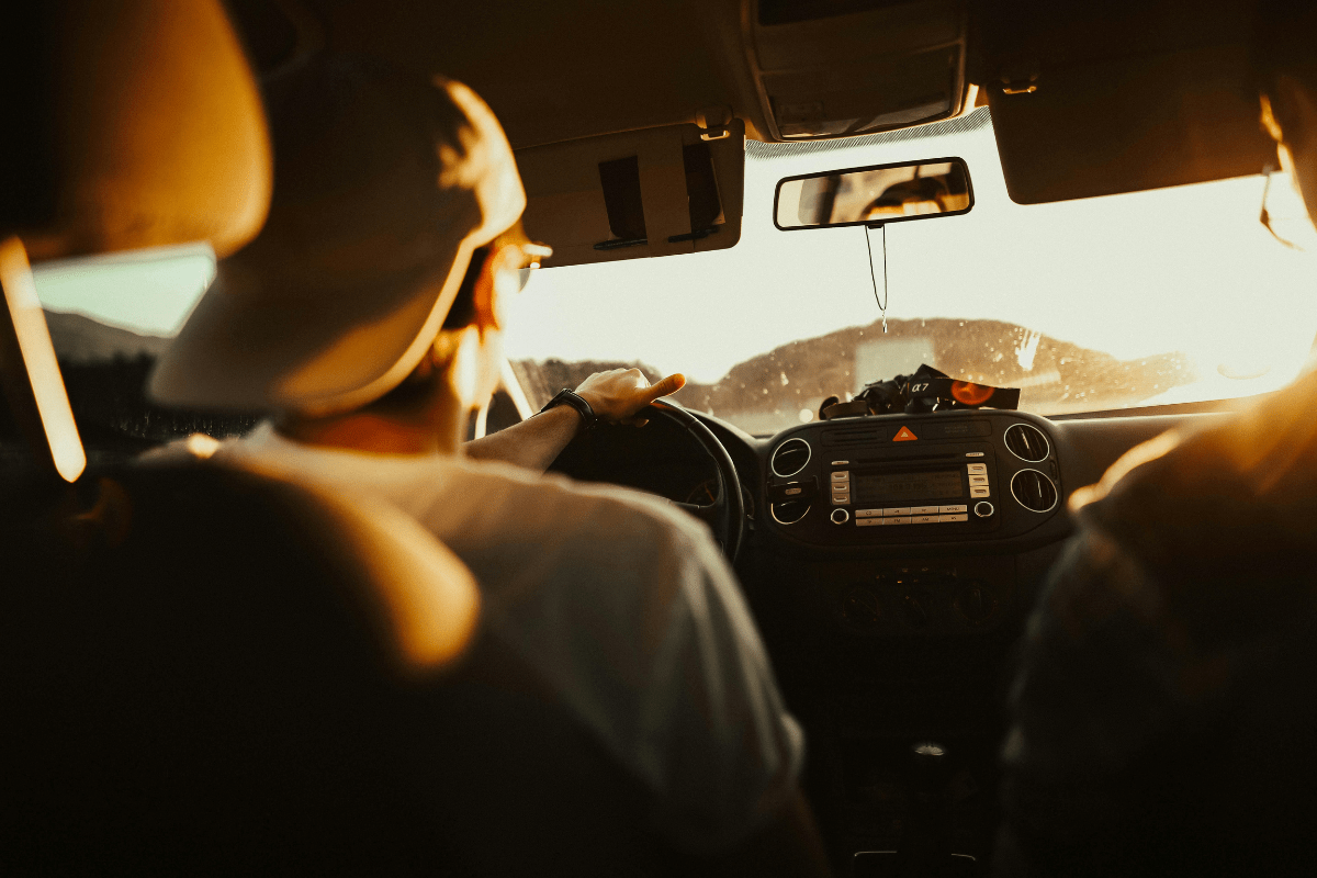 A Man Driving a Car Can be Seen from the Backseat Illustrating Side Hustles That Pay Daily