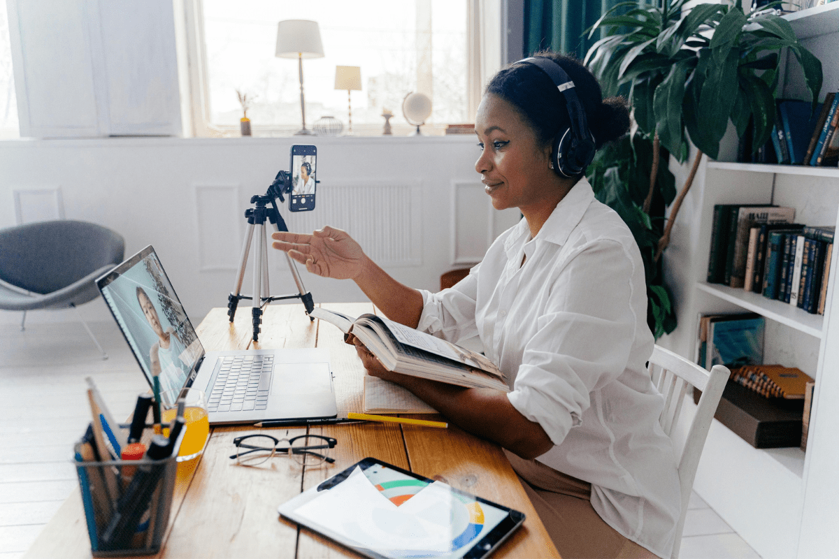Teach Online - Physician Side Gigs and Side Hustles for Doctors A Female Doctor Can be Seen Wearing Headphones and Teaching Some students Via a Video Call Illustrating Some Physician Side Gigs and Best Side Hustles for Students