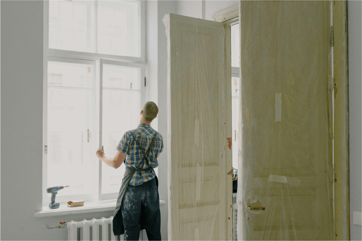 A Worker Fixing a Window Screen Illustrating Handyman Side Hustle