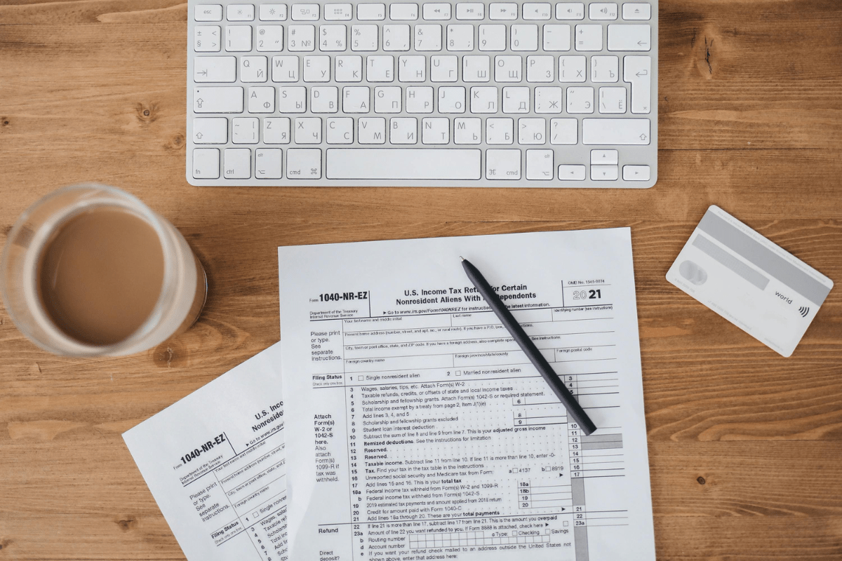 Business Structure - How to Start a Credit Repair Business Tax Papers With a Pen on Top Can be Seen Placed on a Table Close to a Keyboard Illustrating How to Start a Credit Repair Business