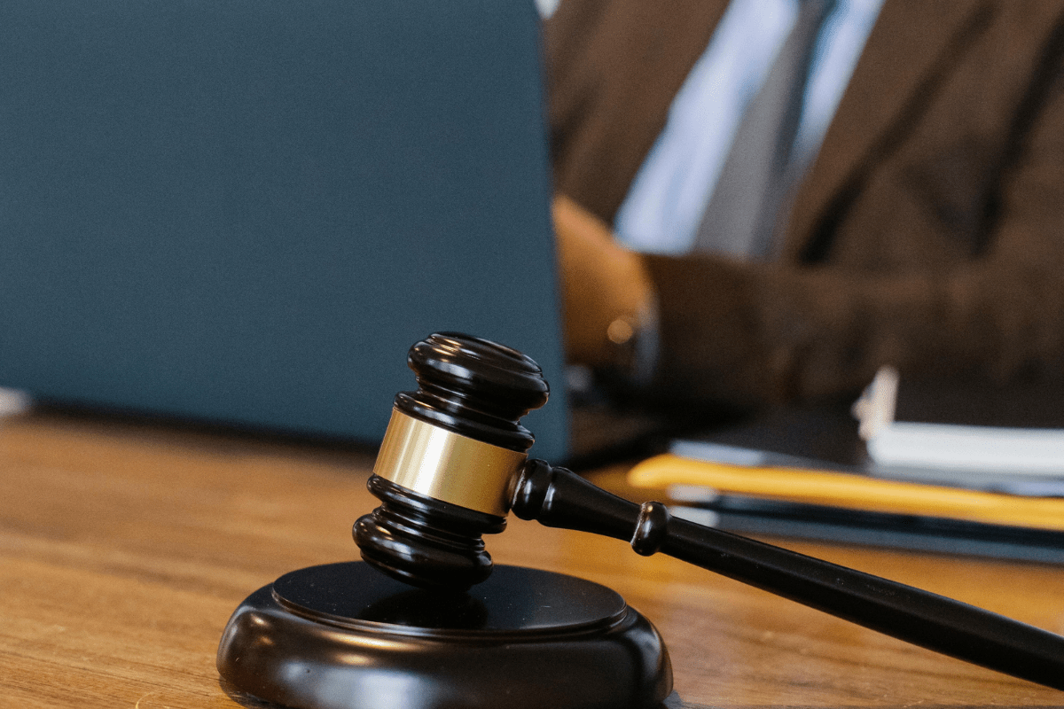 A Person Sitting with a Laptop and a Gavel Placed Nearby on Table Illustrating Side Hustles for Lawyers.