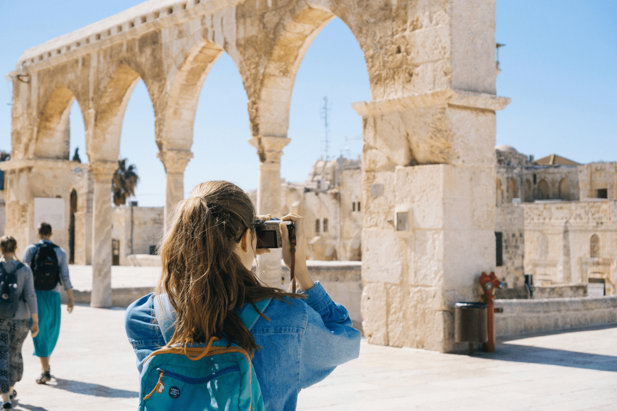 A Tourist Photographing a City Architecture Illustrating How to Start an Airbnb Without Owning Property by Working as an Airbnb Host.