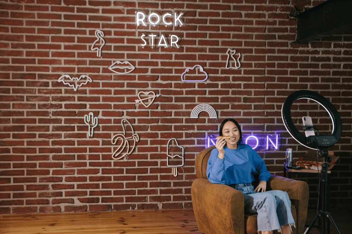 A Woman Sitting in a Studio infront of a Phone Camera Set Against a Ring Light Illustrating How to Make Money on Instagram!