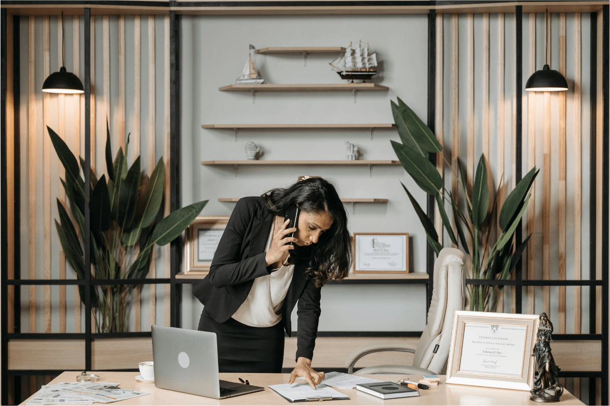 A Woman is On a Call While She is Seeing Something on Her Laptop Illustrating Side Hustles for Lawyers