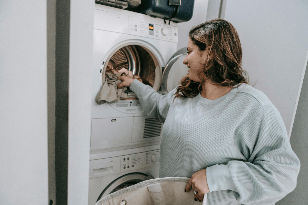 A Woman Loading Clothes in a Front-Load Washing Machine Illustrating How to Start a Coin Laundromat Business