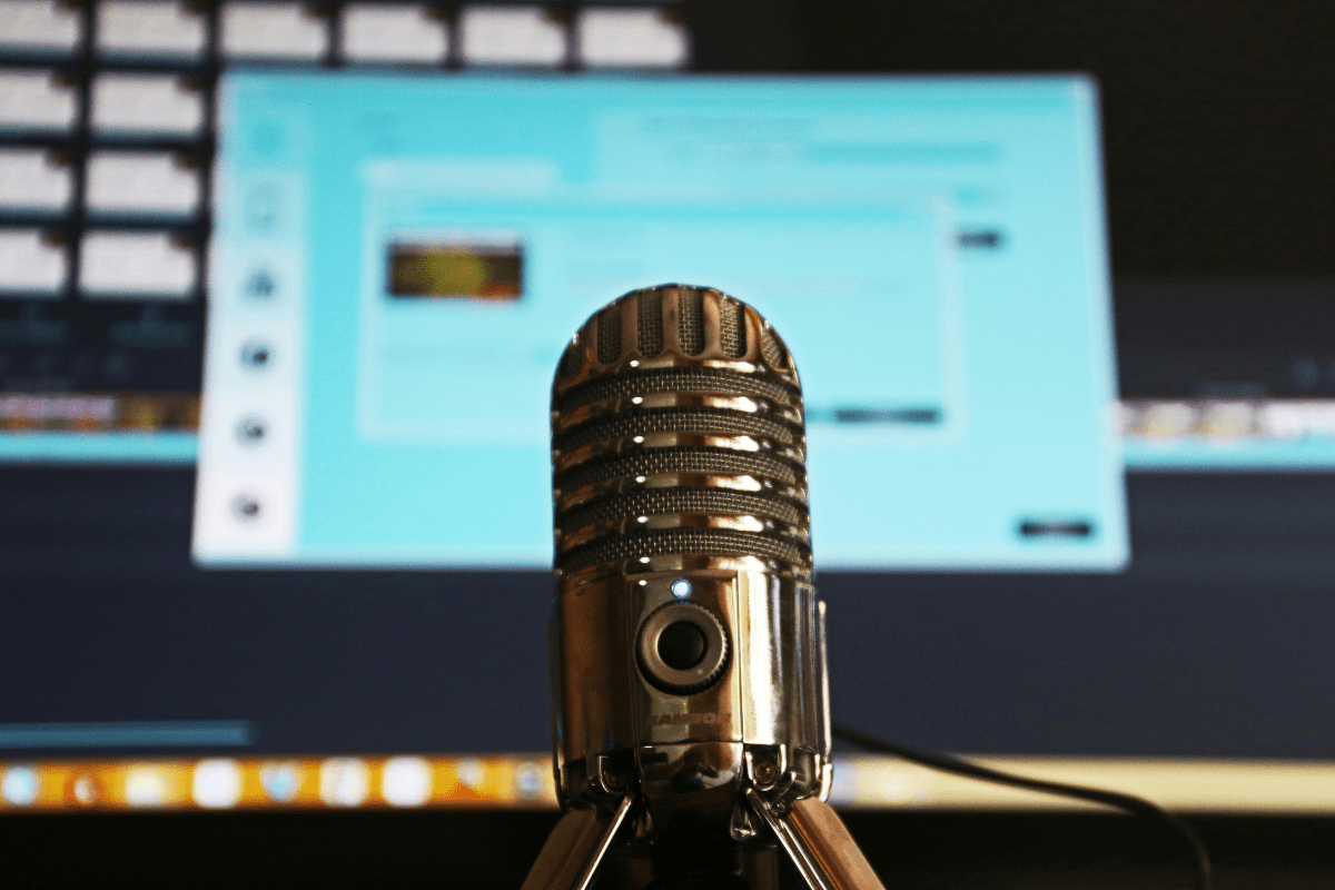 A Mike Can be Seen Placed In Front of a Screen Showing a Podcast Studio Illustrating Side Hustles for Lawyers