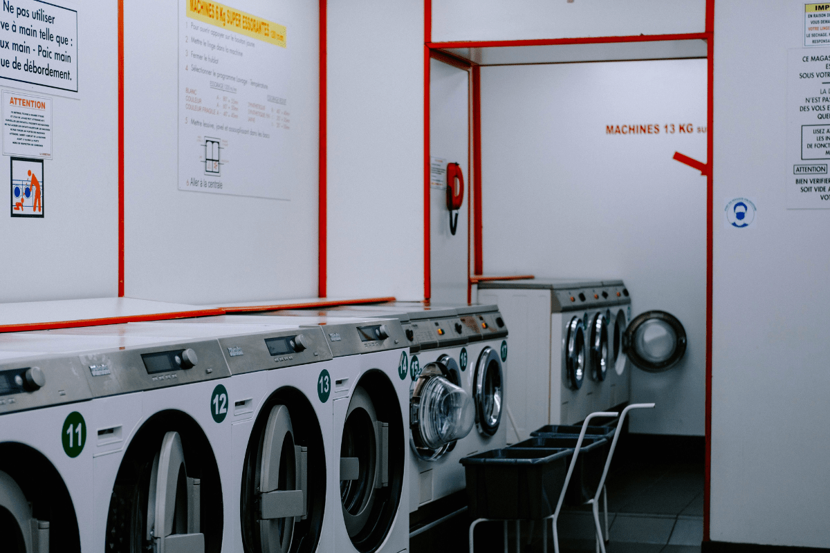 A Laundromat Can Be Seen With Multiple Washing Machines Placed Side by Side Illustrating How to Start a Coin Laundromat Business