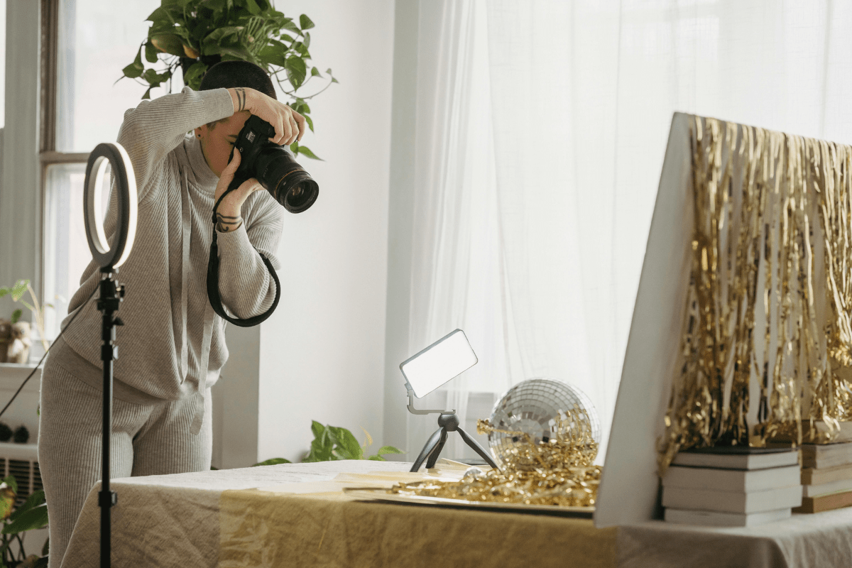 Product Photography - How to Start a Photography Business A woman Photographing Something Set on the Table with Her Camera Illustrating How to Start a Photography Business