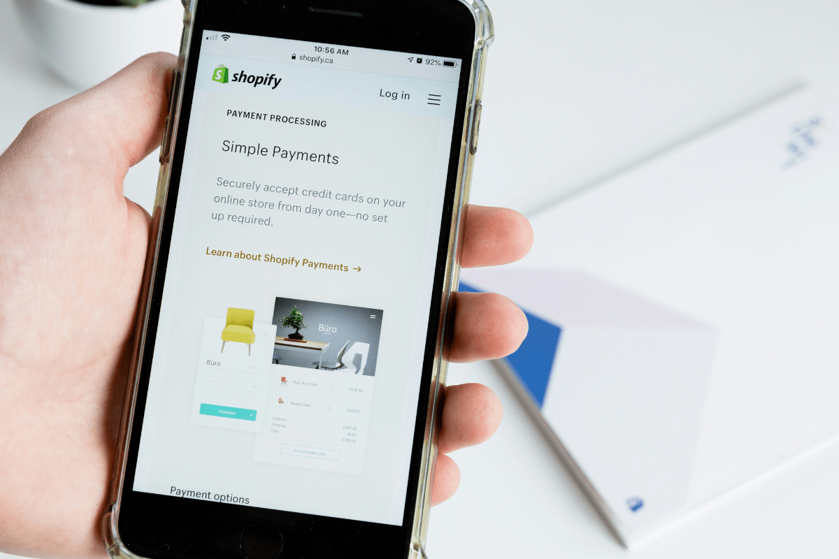 A Mobile Phone Is Held in a Person Hand Displaying Shopify Store Illustrating Best Place to Sell Digital Products Online 