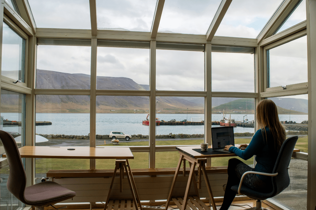 Why Remote Side Hustles are the Future A Woman Working on Her Laptop Sitting By the Window Illustrating Remote Side Hustles