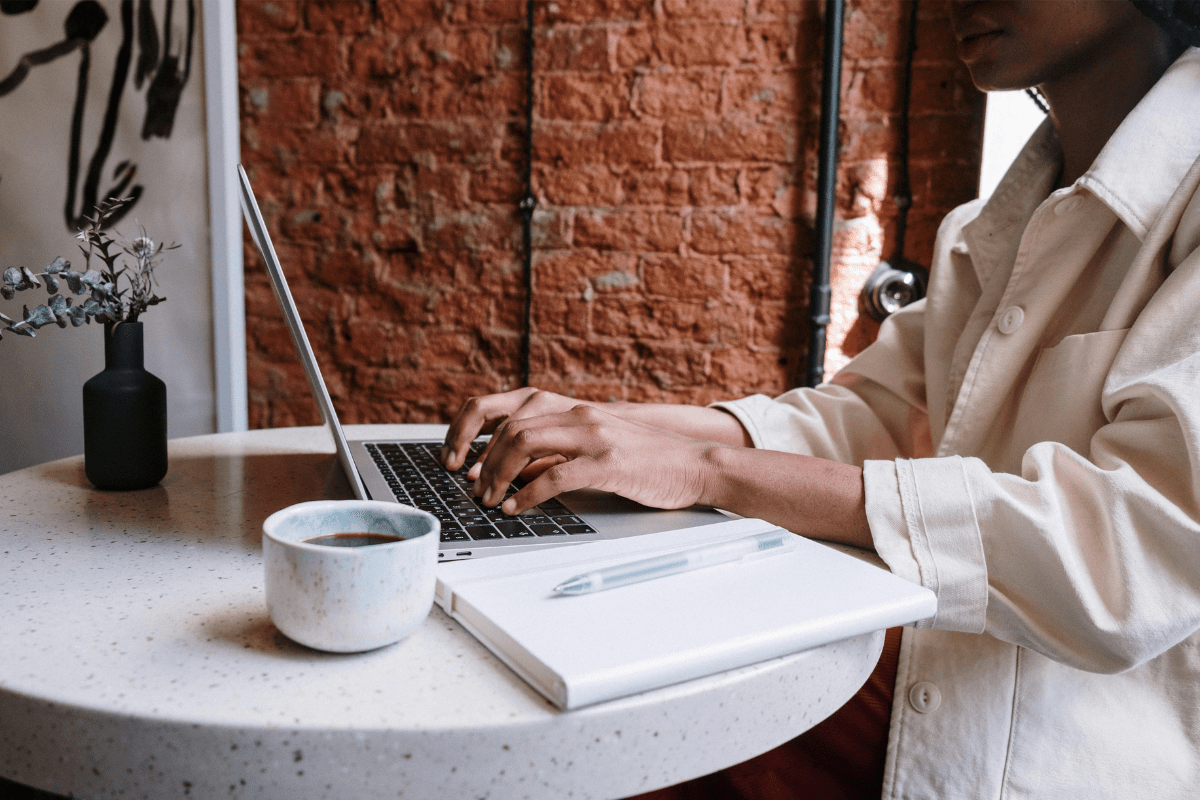 A Woman Can Be Seen Typing on Her Laptop Illustrating Starting a Blog or Publishing a Book as Ways to Earn Passive Income for Doctors