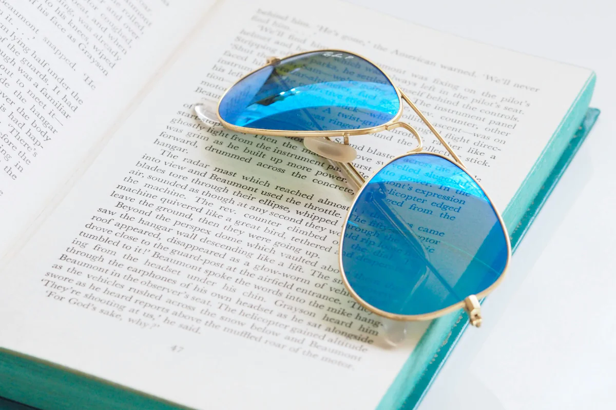 Research is Necessary when Starting any Business. A picture of Sunglasses Lying on a Book Page Illustrating How to Start a Sunglasses Business