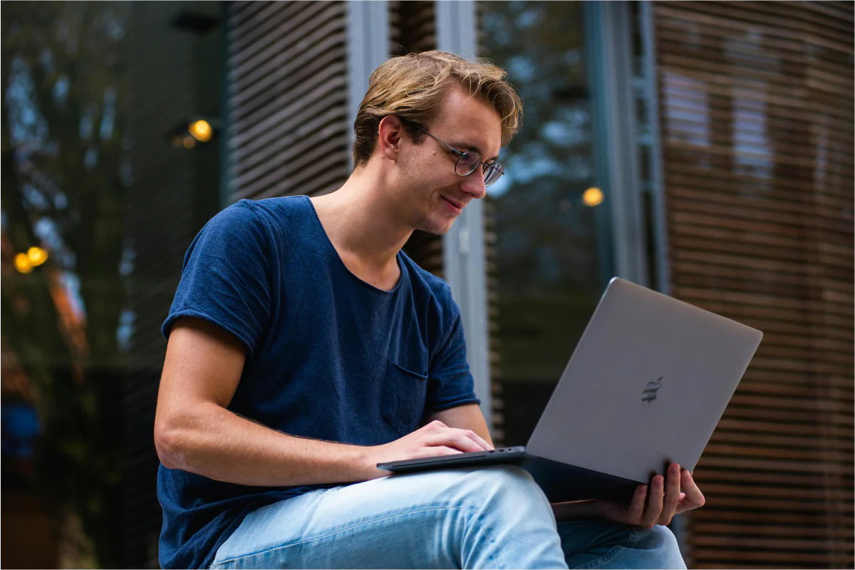 A Person Working on Their Laptop Choosing a Business Model for Their Business Illustrating How to Start a Sunglasses Business