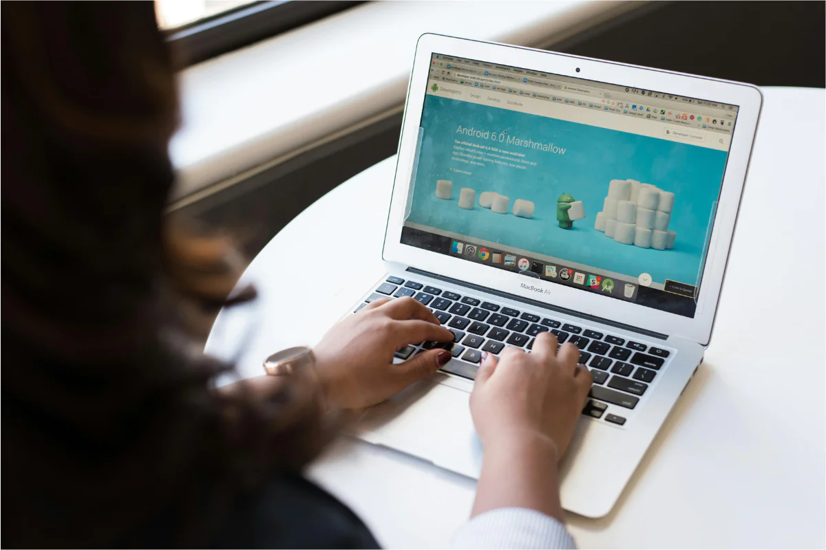 A Woman Can Be Seen Using Her Laptop. A Website is Open Illustrating How to Start a Sunglasses Business.