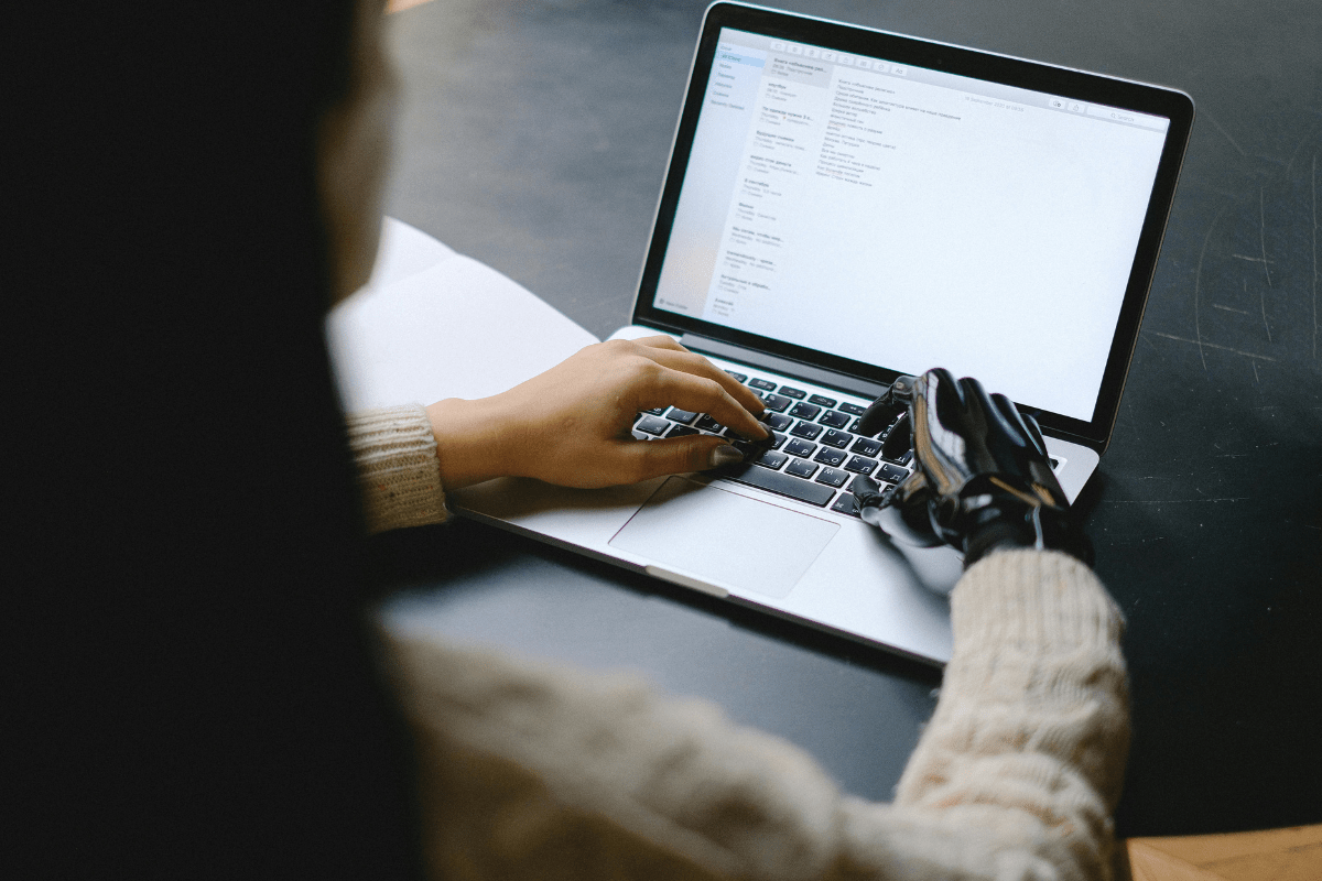 Become a Research Assistant - Easy Jobs for Disabled Adults A Person Cane Be Seen From Back Working on Their Laptop Illustrating Easy Jobs for Disabled Adults