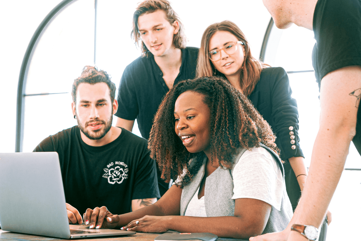 A Group of People are Sitting in Front of a Laptop Discussing a Digital Marketing Business Illustrating Is Digital Marketing Legit?