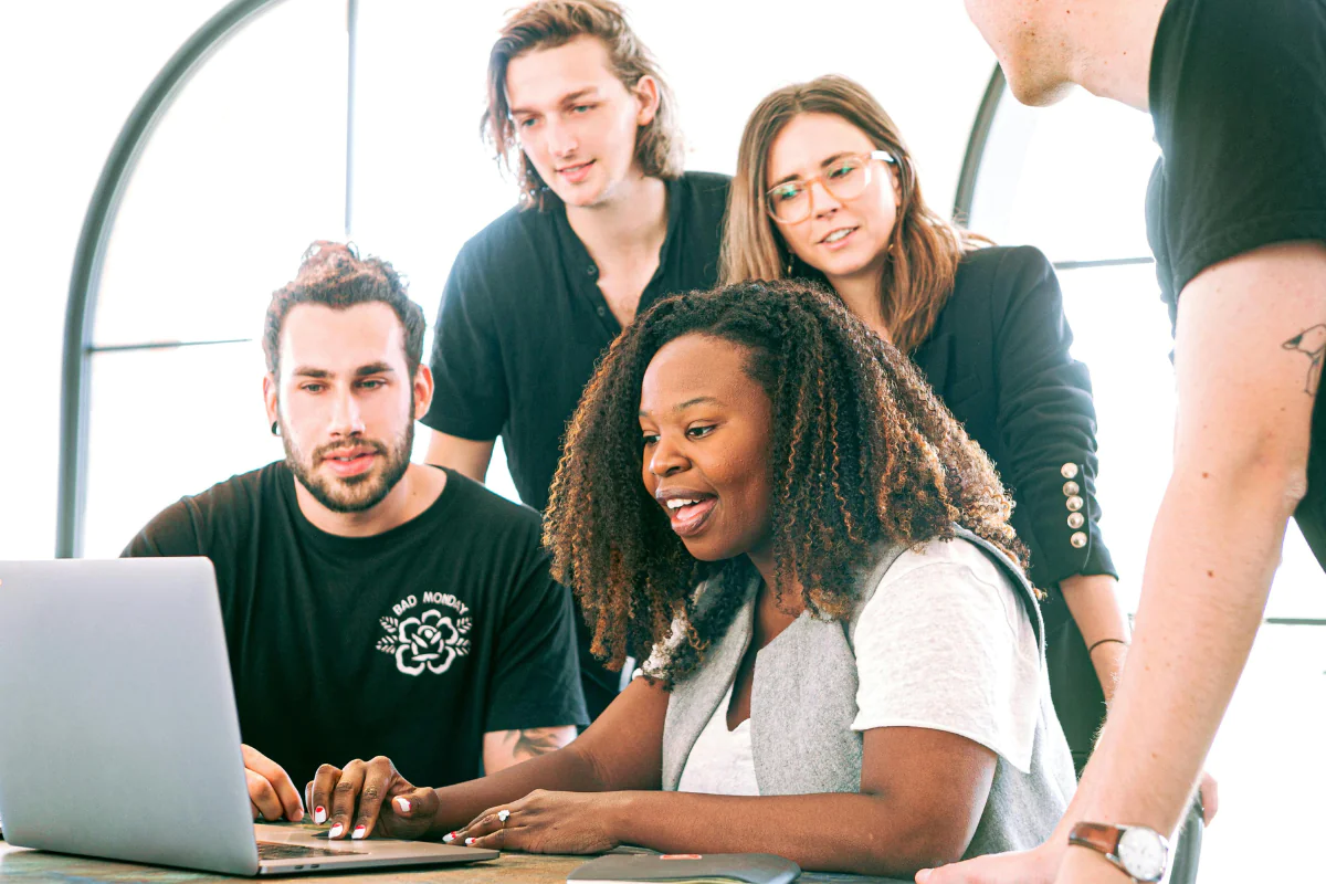 A Group of People are Sitting in Front of a Laptop Discussing a Digital Marketing Business Illustrating Is Digital Marketing Legit?