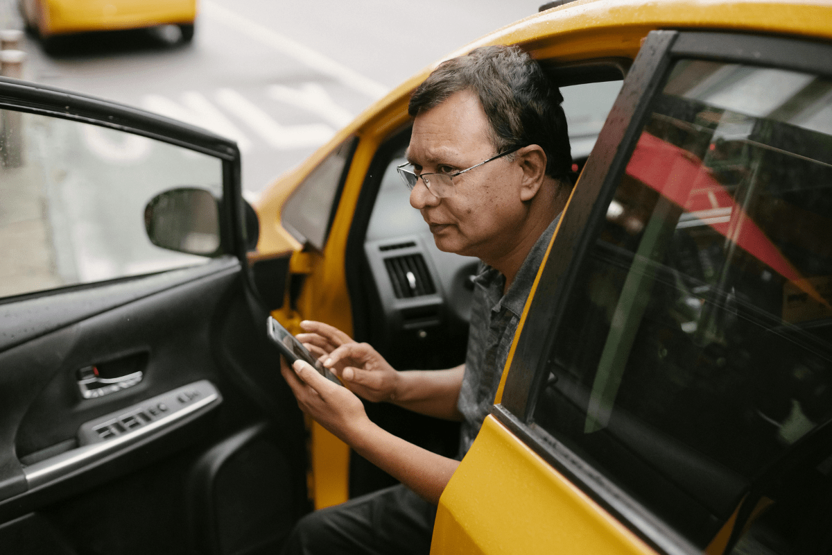 A Person Is Sitting in the Driving Seat of a Taxi Illustrating Side Hustles for Men