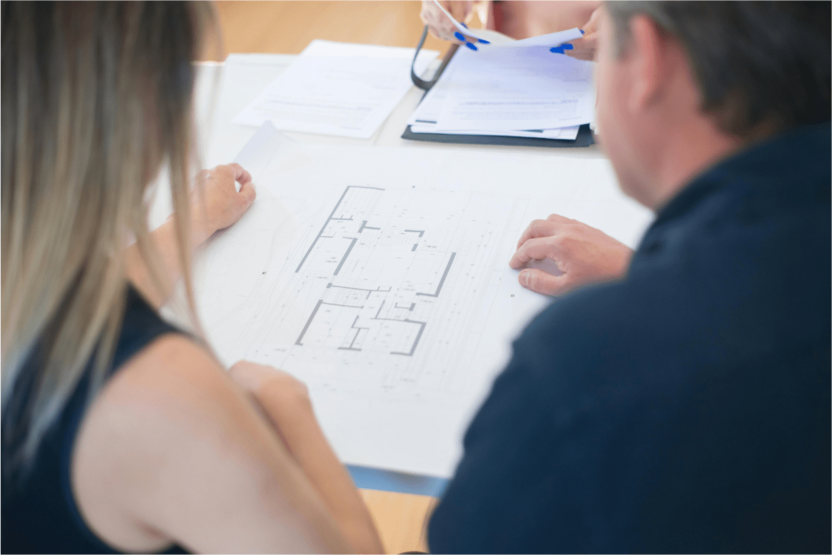 Work as a Freelance Designer - Best Side Hustles for Engineers Two People Can Be Seen Discussing Something Related to a Desing Placed Infront of Them Illustrating Best Side Hustles for Engineers